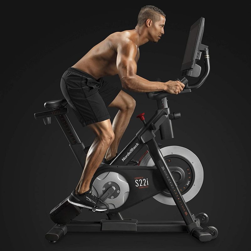 NordicTrack Commercial Studio Cycle S22i with a male rider against a black background.