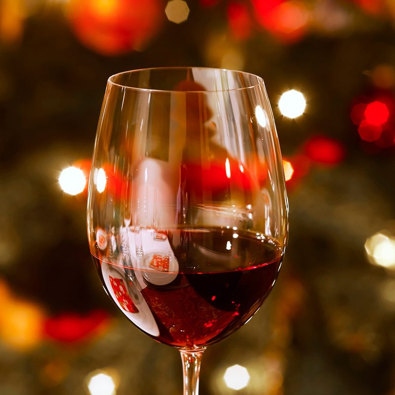 Glass of red wine at Christmas time, close-up.