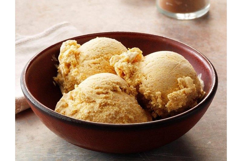 three scoops of spiced persimmon ice cream in a bowl.