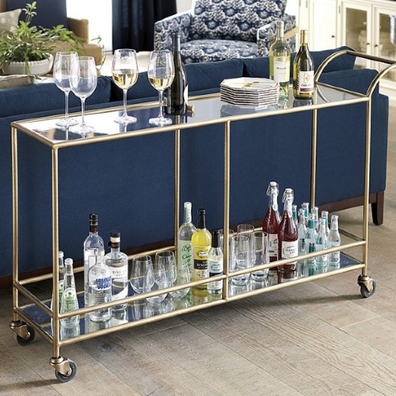 long bar cart sitting agains the back of a sofa.