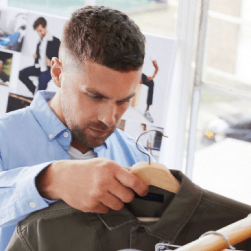 Man choosing clothing in store.