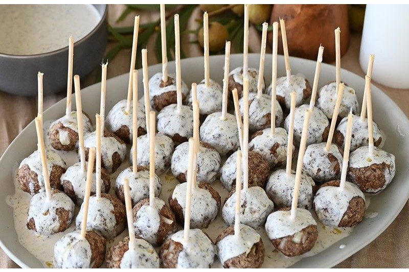 Venison meatballs with creamy dill sauce served with skewers.