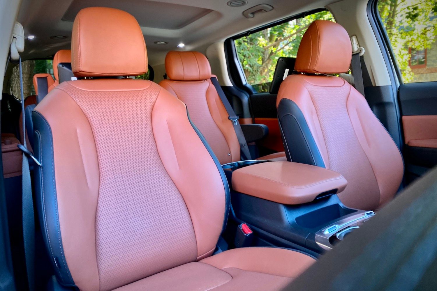 Kia Carnival front passenger seat with trees in the back.