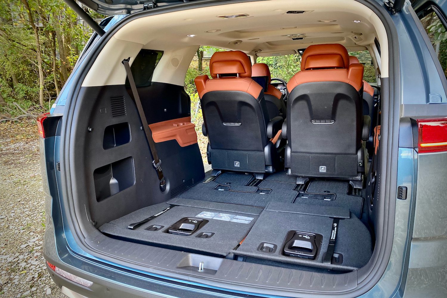 Kia Carnival cargo area with third-row seats stowed and liftgate open.