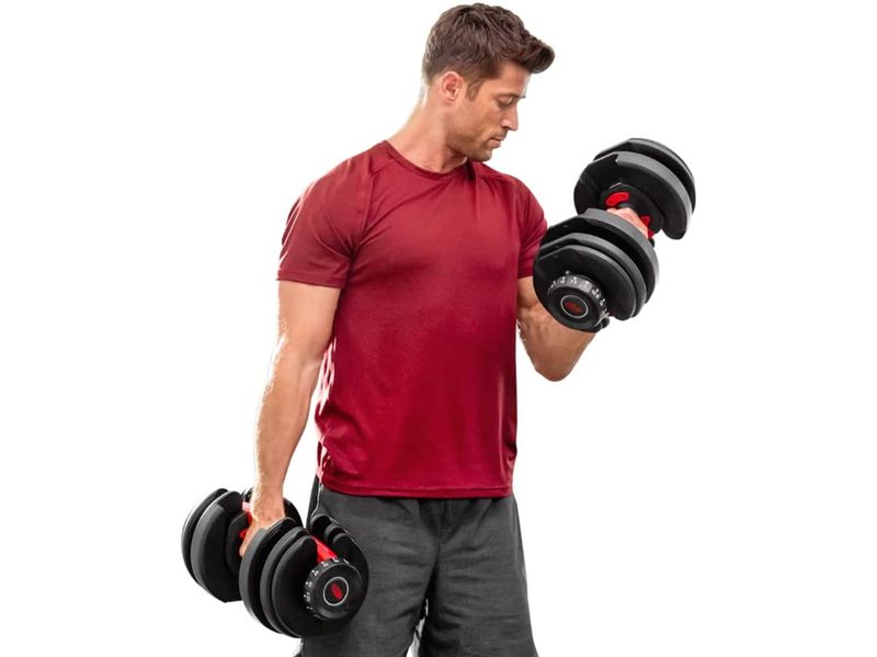 A man does bicep curls using Bowflex SelectTech 552 Adjustable Dumbbells.