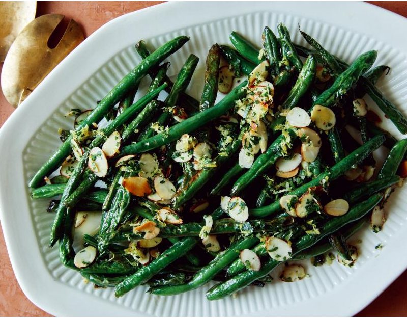 air fryer green beans garnished with almond slivers in a white serving bowl.