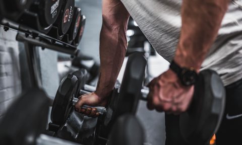 Man grabbing dumbbells