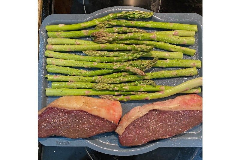 Raw steak with asparagus.