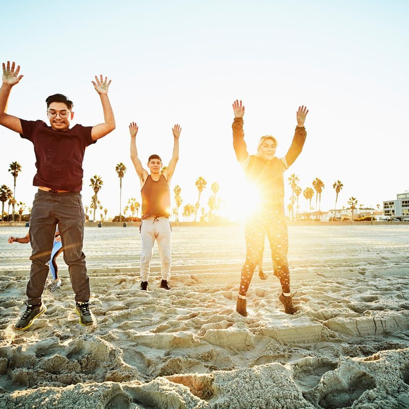 Group of friends doing burpees in the morning at the beach.