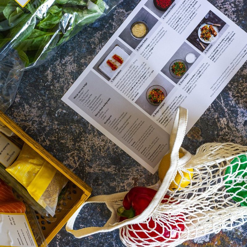 meal kit recipe instruction card next to meal kit ingredients.