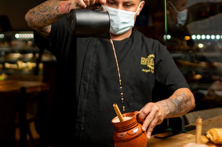 Chef Luis Parra pouring chocolate into a jug.