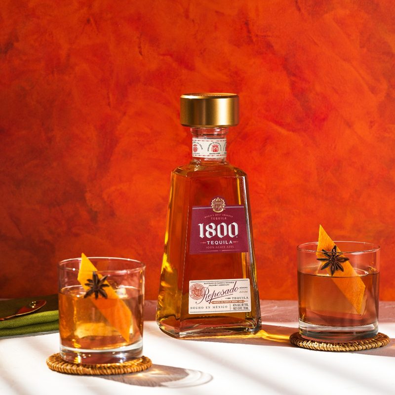 Cranberry Orange Maple cocktails sitting next to Jose Cuervo 1800 bottle.