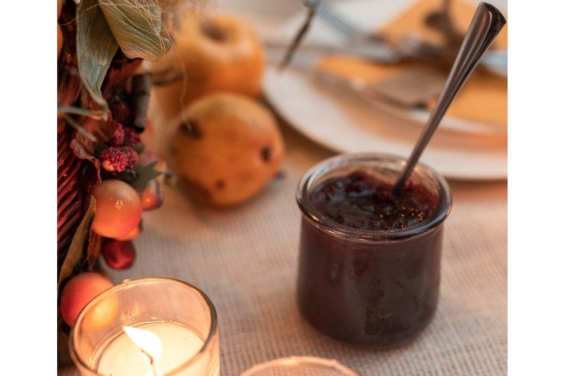 Cranberry sauce in a glass jar on a festive fall table