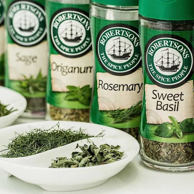 jars of dried herbs behind bowls of dried herbs.