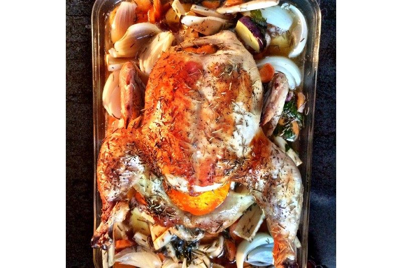drunk chicken in a roasting pan with vegetables.