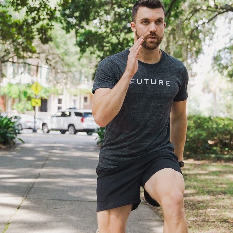 Future coach with Apple Watch doing lunges in park.