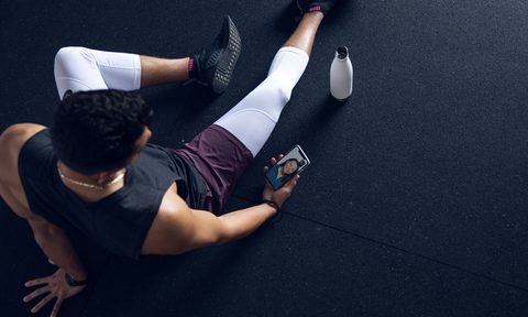 Future virtual personal trainer service used on mobile with bottle nearby.