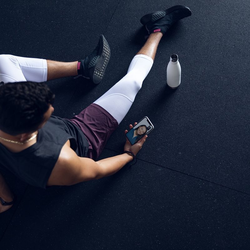 Future virtual personal trainer service used on mobile with bottle nearby.
