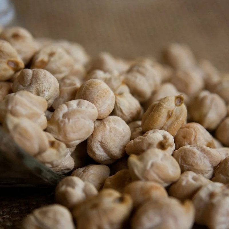 A close-up of Garbanzo beans spilling from a basket.