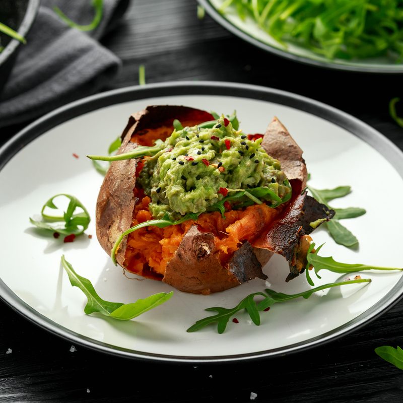 A baked sweet potato boat on a plate.