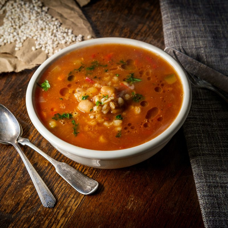Hearty Tomato and Cannellini Bean Soup with spoons and beans on the side.