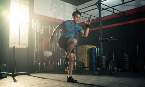 Athletic man doing high knees at a gym
