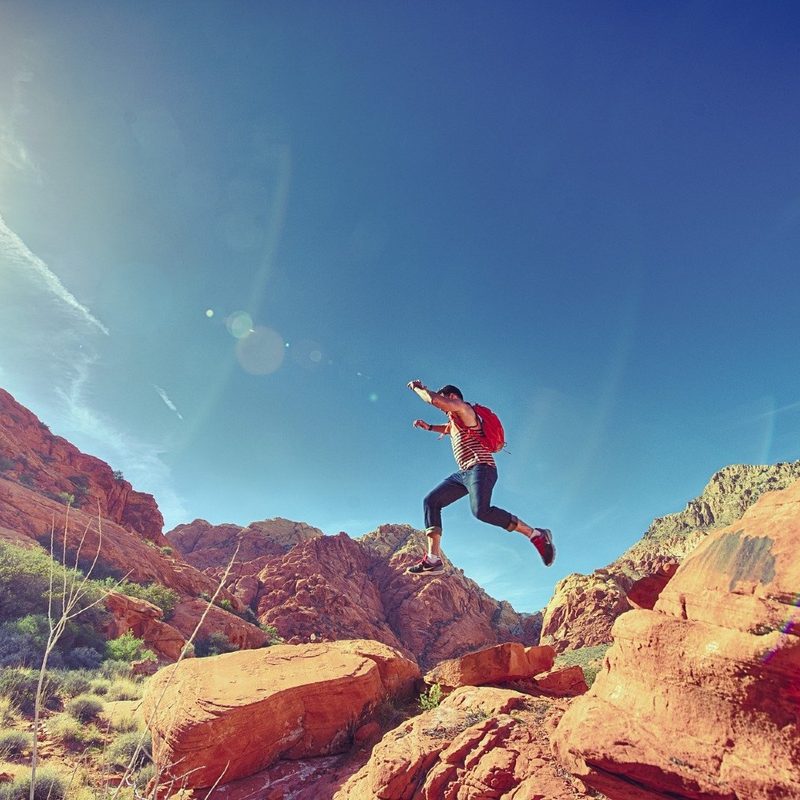 Hiker jumping rocks on a warm day