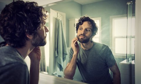 Man grooming in bathroom.