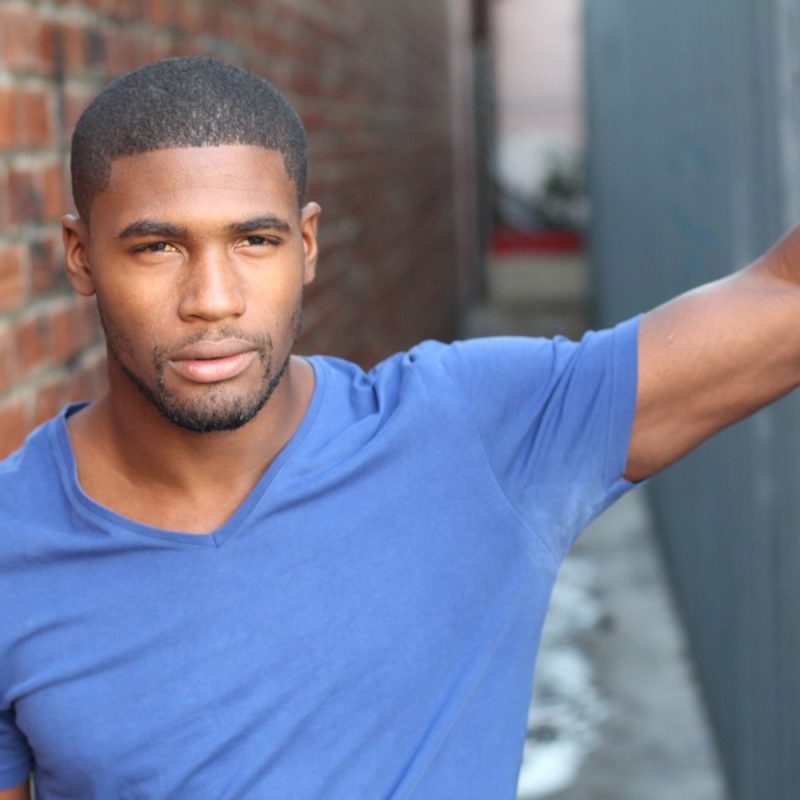 Man with deodorant stains on the armpit area of his blue shirt.