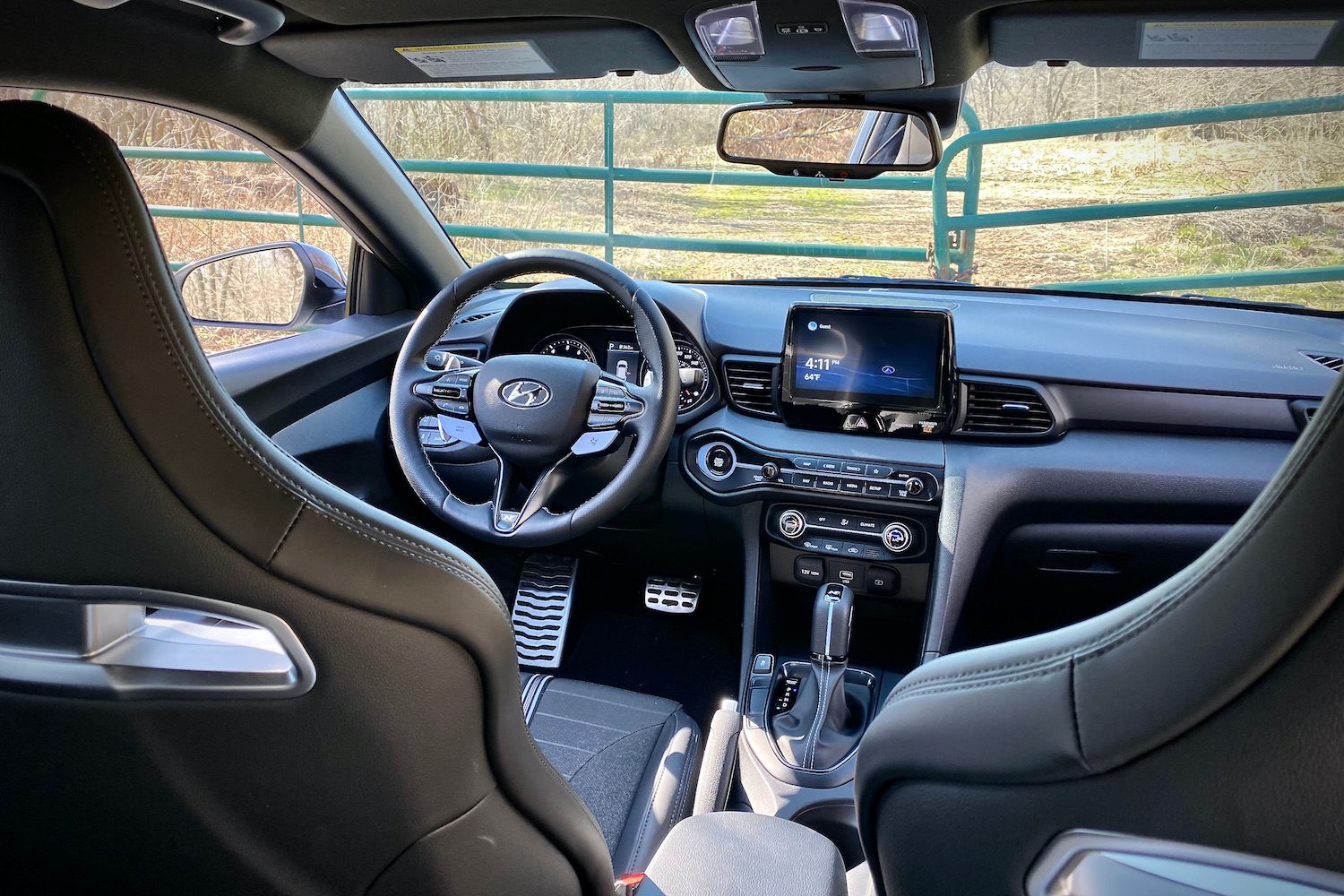 Hyundai Veloster N dashboard from the back seats with a fence in the background.