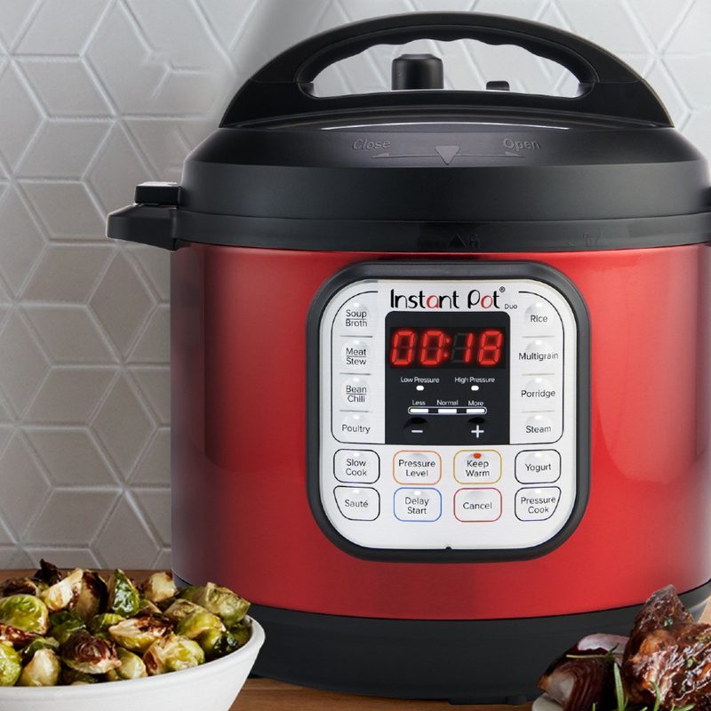 Instant Pot 6-quart Duo Stainless Steel Pressure Cooker, Red on a counter with food.