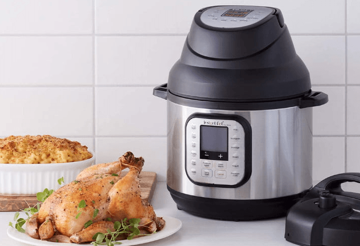Instant Pot on a kitchen counter with a roast chicken and casserole dish of mac and cheese.