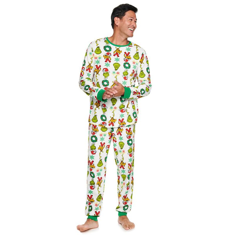 A smiling model wearing The Grinch pajamas.