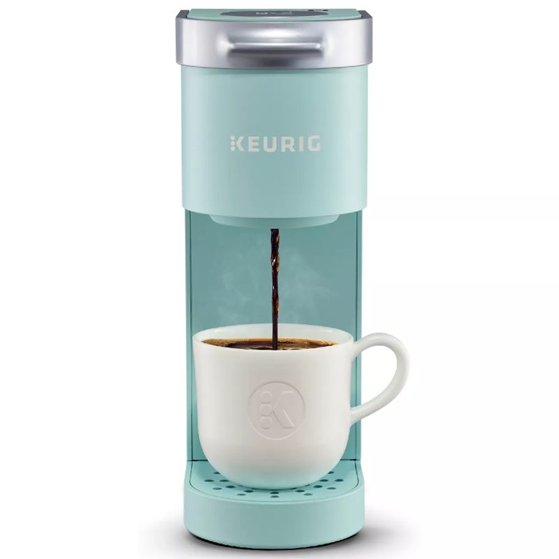 Keurig K Mini Coffee Maker and coffee cup on a white backdrop.