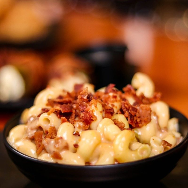 Bowl of creamy mac n' cheese with bacon on top.