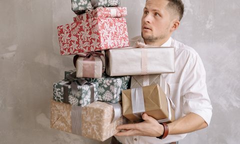 Man juggling gifts before the holidays.