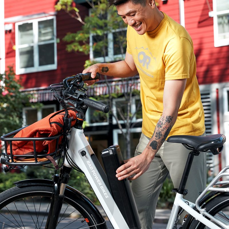 Man removing battery from RadCity 5 Plus e-bike to charge it.