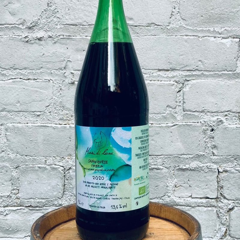 Bottle of Mani Di Luna 'Rosso Sangiovese IGT against a wall.