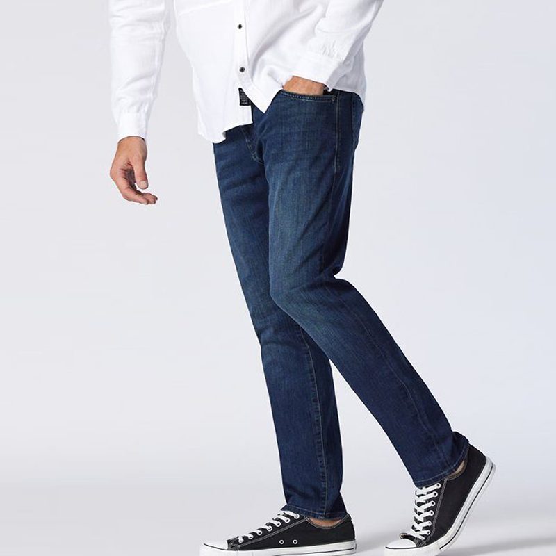 A midsection of a male model wearing a pair of Mavi Jake Dark Sky Williamsburg Jeans.