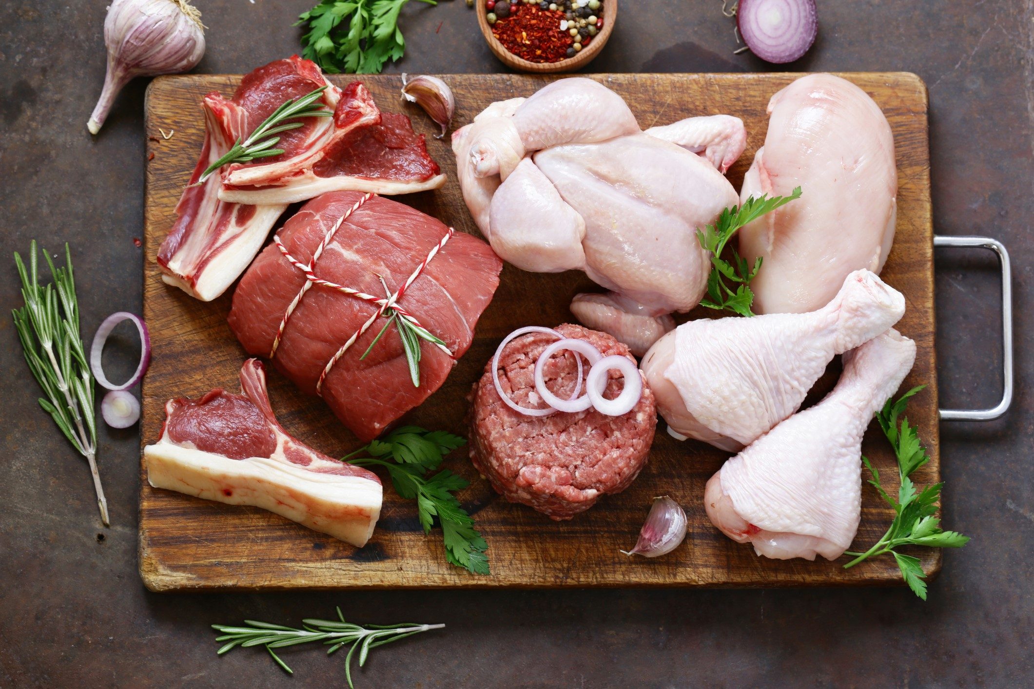Meat and poultry served on a chopping board.
