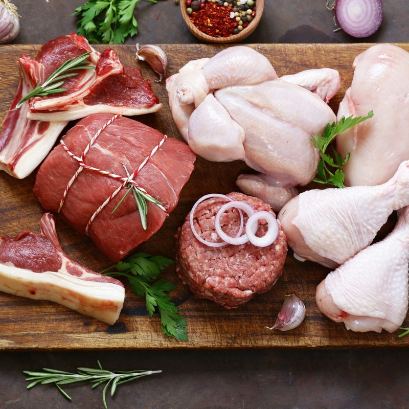 Meat and poultry served on a chopping board.