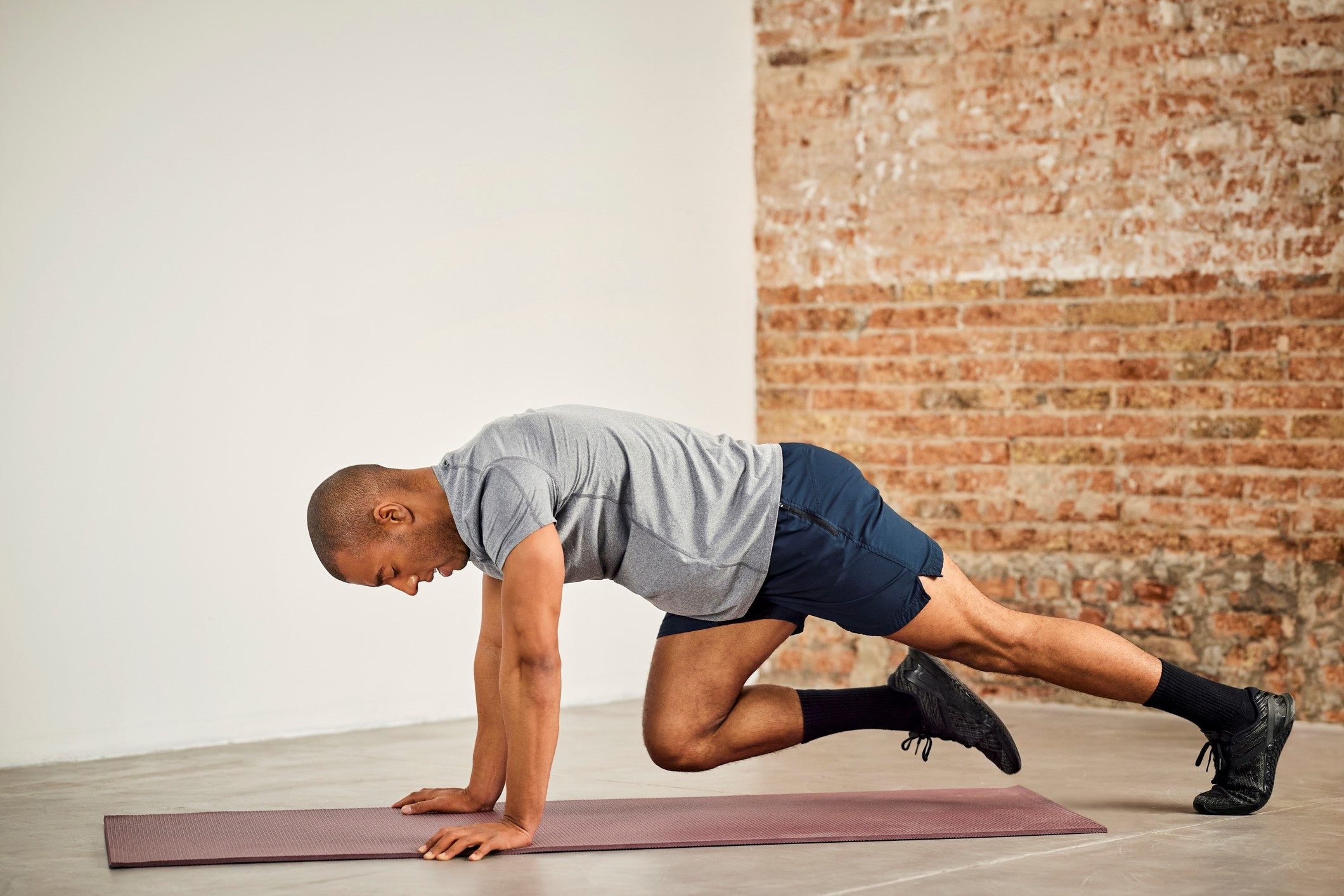 Man doing mountain climbers on a mat