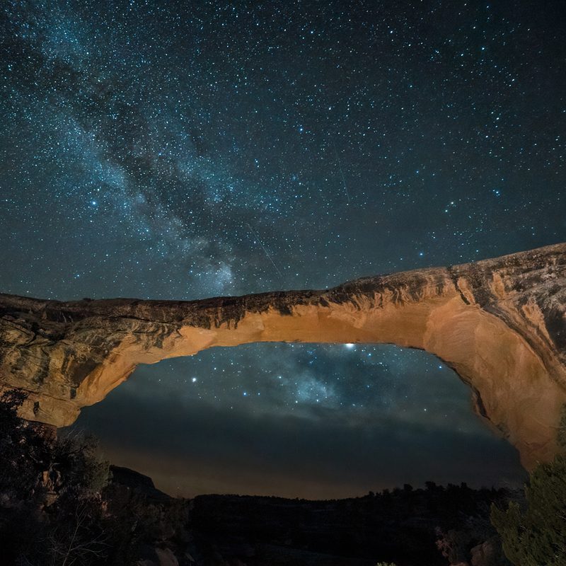 A breathtaking view of the Owachomo Natural Bridge against a starlit sky.