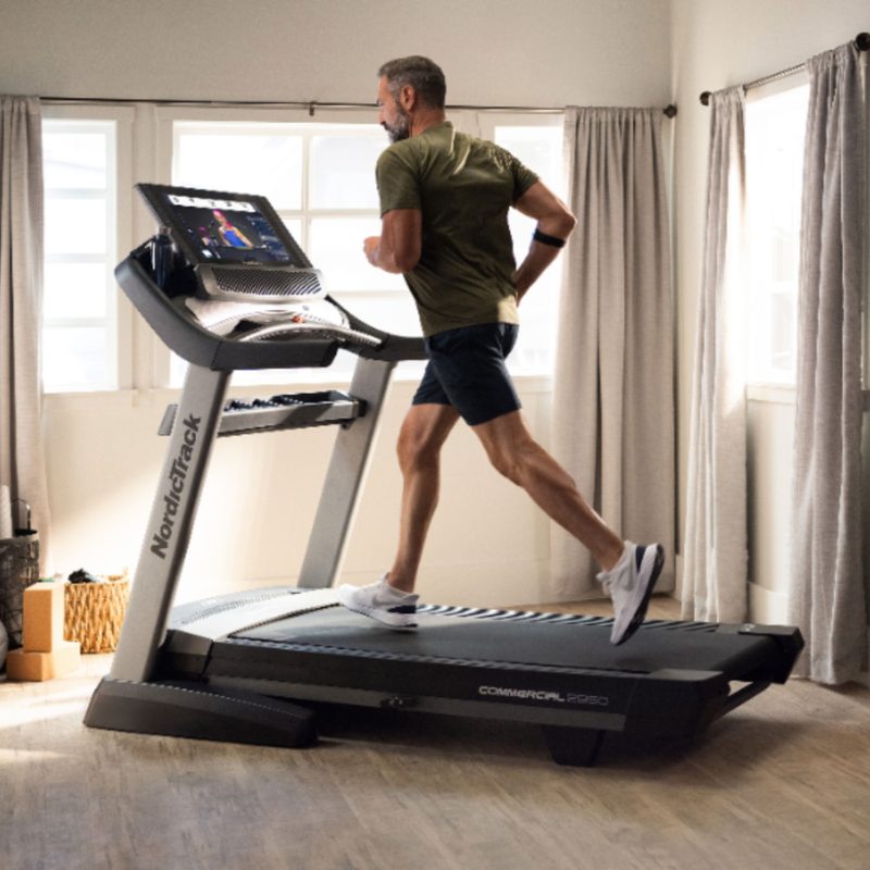 A man running on a NordicTrack Commercial 2950 Treadmill.