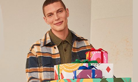 Nordstrom shopper carrying a pile of gifts.