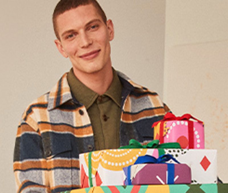 Nordstrom Gift Suggestions with person carrying wrapped presents.