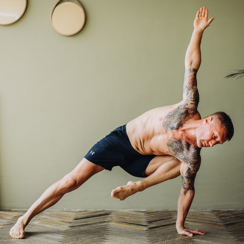 Man doing a side plank yoga pose.