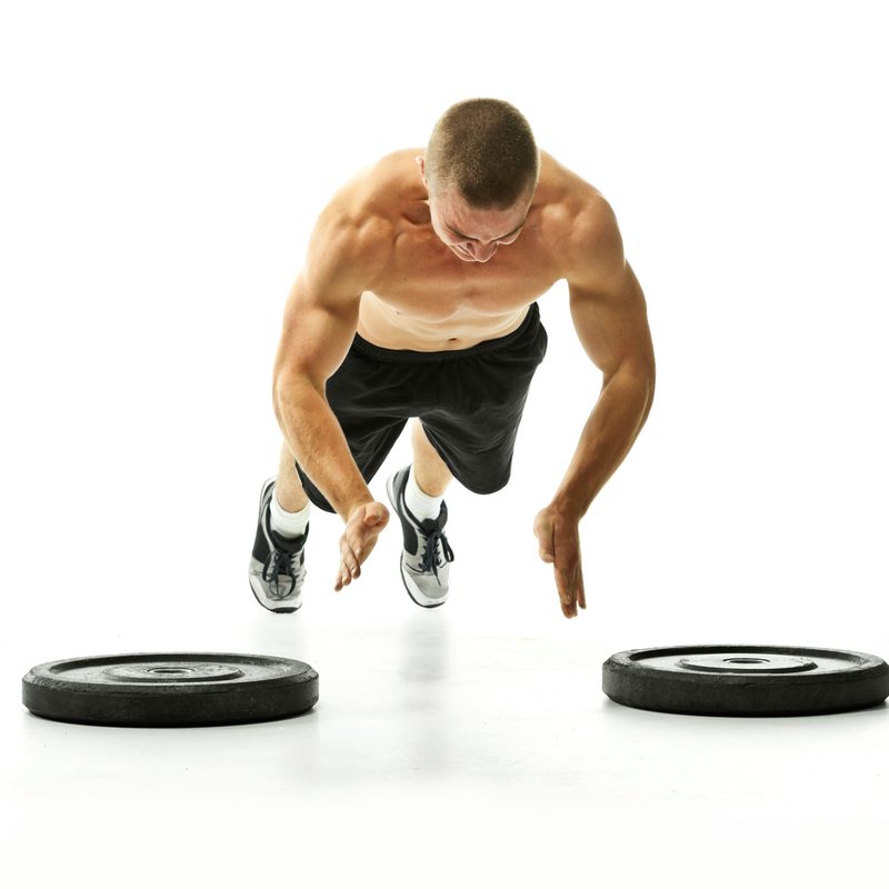 Man doing plyometric push-ups on white background.