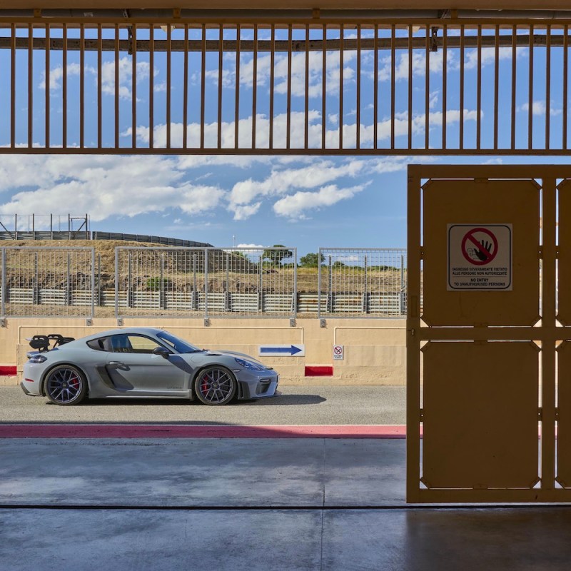 Porsche 718 Cayman GT4 RS side profile with track in the background.