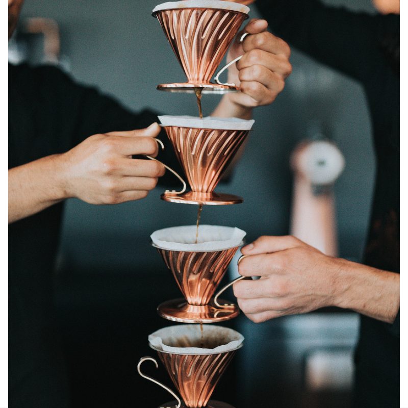 four Pour over coffees dripping into each other.